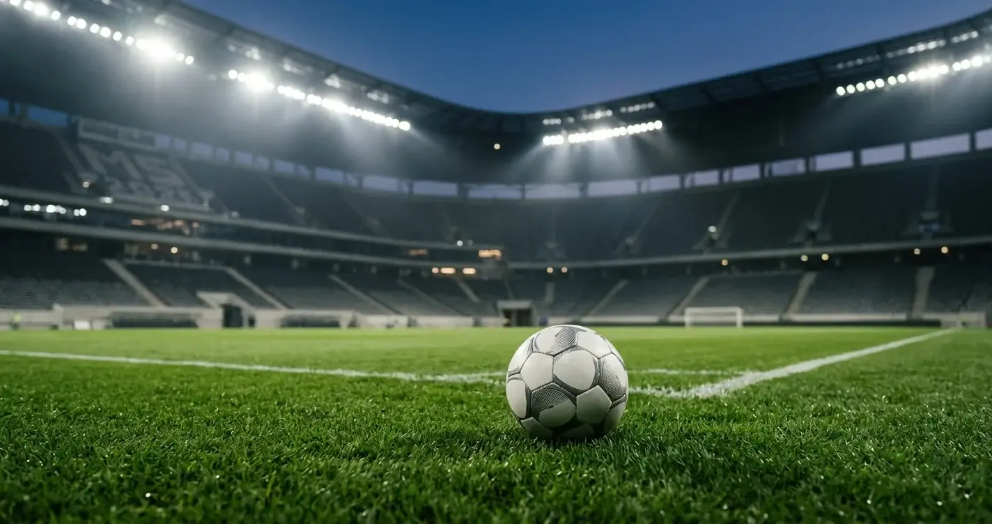 Fotbalov&yacute; m&iacute;č na tr&aacute;vn&iacute;ku osvětlen&eacute;ho stadionu ve večern&iacute;m světle